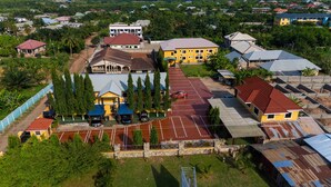 An aerial view of a hotel with a central building surrounded by parking and greenery. - Eastern Plus Hotel  (Somanya)