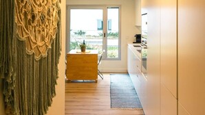 A modern kitchen with a wooden countertop and a built-in oven. - Baia Rio by Proud Progress Homes (Seixal)