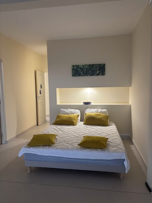 Un dormitorio con cama, una mesita de noche y una lámpara de pared.