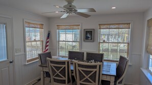 A dining area with a table and four chairs, a ceiling fan, and windows with blinds. - Incredible 3-bedroom house WITH BOAT DOCK on Rehoboth Bay (Millsboro)