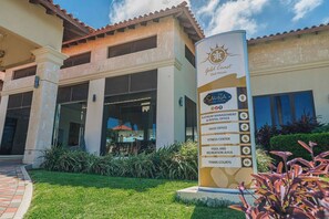A hotel entrance with a sign listing amenities including a Platinum Management & Rental Office, Sales Office, Fitness Center, Pool and Recreation Area, and Tennis Courts. - Stylish Gold Coast Condo Sunrise by Bocobay (Noord)