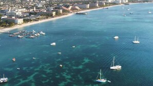 An aerial view of a coastal city with a marina filled with boats, a beach, and buildings along the shore. - Stylish Gold Coast Condo Sunrise by Bocobay (Noord)