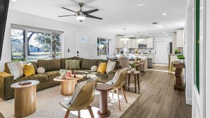 Ein geräumiges Wohnzimmer mit einer großen Couch, einem Couchtisch und einem Essbereich mit Stühlen und Tisch.