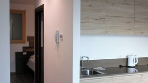 Une cuisine moderne dotée d’un évier encastré, d’une bouilloire et d’un plan de travail en bois.