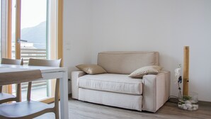 Un salon minimaliste avec un canapé beige, une table à manger et des chaises.
