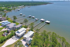 An aerial view of a waterfront property with multiple buildings, docks, and a marina. - Cozy Bayfront Guest Cottage - Boat Friendly Dock! (Elberta)