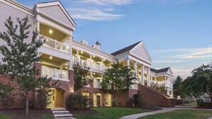 A multi-story hotel with a central courtyard, balconies, and a brick facade. - Spacious 2-Bedroom Williamsburg Escape, Just Moments from Busch Gardens (Williamsburg)