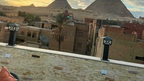 Vista delle piramidi con cielo sereno e un edificio sullo sfondo.