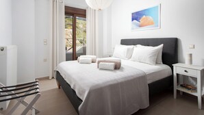 A modern bedroom with a large bed, a bedside table, a chair, and a view of the outdoors.