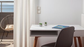 A modern room with a white desk, a grey chair, two small potted plants, and a book titled "The Art of War".