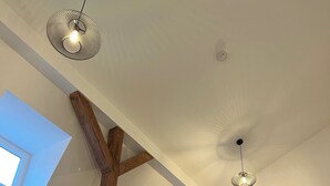 A staircase with wooden railings and a ceiling with skylights and pendant lights. - Modern 1-room apartment in a historic setting next to the New Palace (Bayreuth)