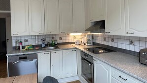 A kitchen with white cabinets, a dishwasher, an oven, a coffee maker, and a toaster. - Lovely 2-br 77m2 Apart Pasila-train Station (Helsinki)