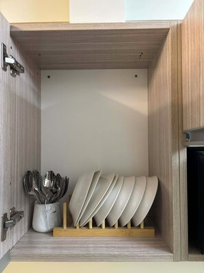 A kitchen cabinet with a built-in utensil holder containing multiple spoons and a bowl. - Stunning CCLEX Views from This High-Floor 1-Bedroom (Cebu City)