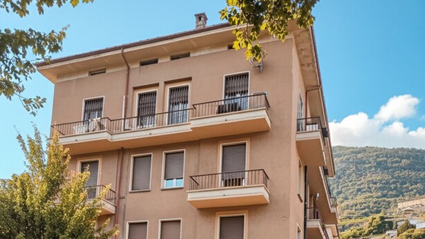 A multi-story building with a ground-floor entrance, balconies, and a visible restaurant sign. - "Valeri" Vacation Rental in Sondrio - Peaceful Stay Near City Center (Sondrio)
