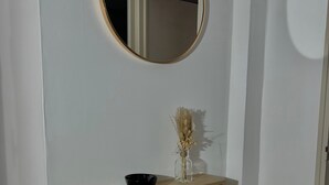 A wooden dresser with a mirror above it, a black bowl, and a vase with dried flowers. - Accommodation in a small character house in SAINT GENIES (Saint-Geniès)