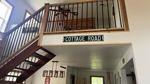 Puiset portaat, joiden yläpäässä on kyltti, jossa lukee ”COTTAGE ROAD”, ja toinen kyltti, jossa ilmoitetaan, että paikka on avoinna 24 tuntia vuorokaudessa.