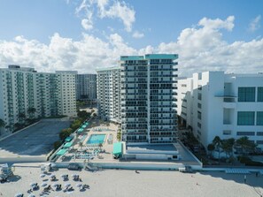 A high-rise hotel with multiple floors, a swimming pool, and a beach area with umbrellas. - Stunning Penthouse on Hollywood Beach (Hollywood)