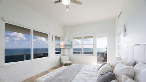 A bedroom with a large bed, a chair, and a view of the ocean through large windows. - Stunning Penthouse on Hollywood Beach (Hollywood)