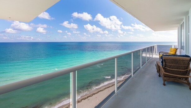 A balcony with a view of the ocean, wicker furniture, and a railing. - Stunning Penthouse on Hollywood Beach (Hollywood)
