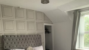 Ein Schlafzimmer mit einem großen Bett, einem Kleiderschrank und einer Pendelleuchte.