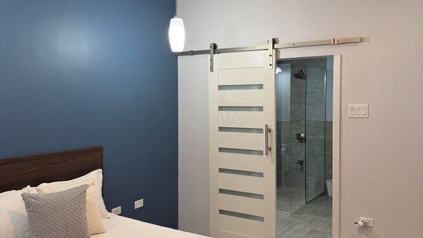 Quarto com cama, ventoinha no teto, porta deslizante e luz noturna.