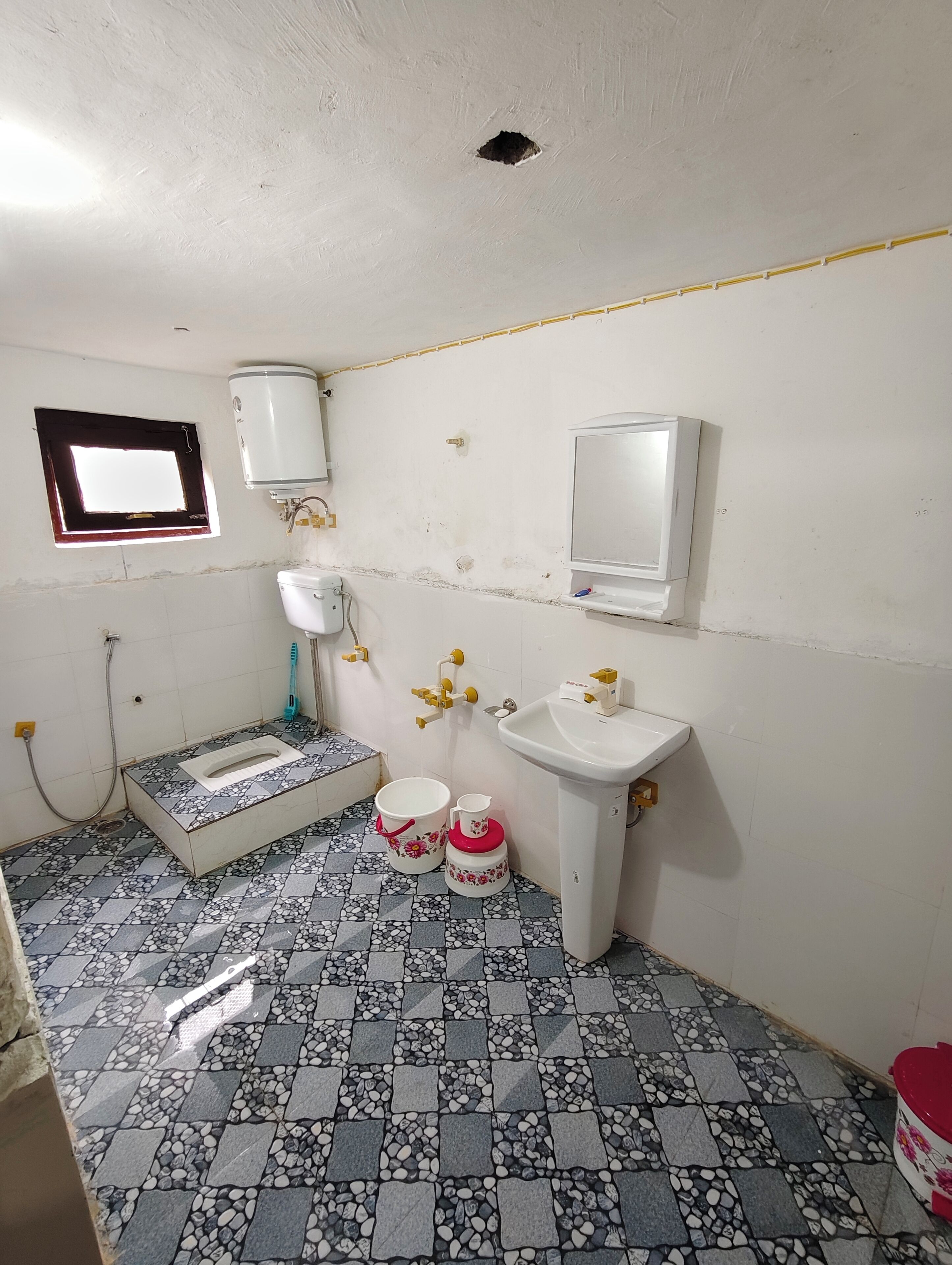 A small bathroom with a toilet, sink, and a window.