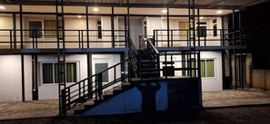 A multi-level building with a staircase, multiple rooms, and a balcony.