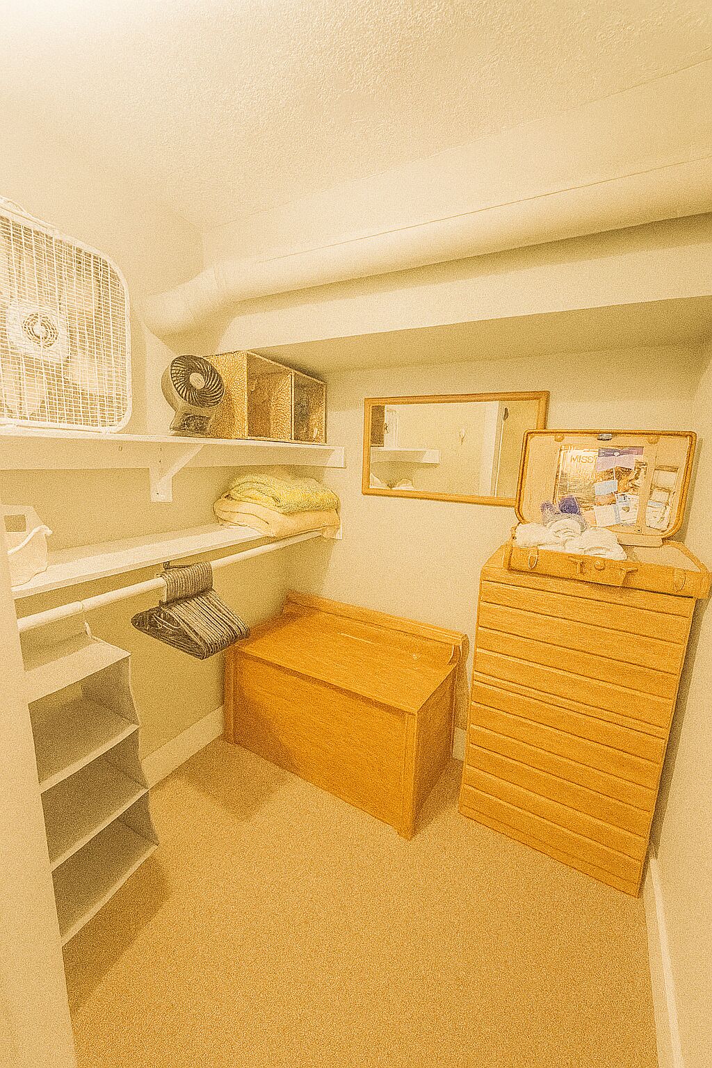 A compact room with a desk, a small bench, and a filing cabinet.
