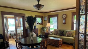 A dining area with a round table, chairs, and a vase with decorative feathers.