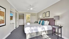 A modern hotel room with a large bed, a desk, and a ceiling fan. - Ar' Heafy Lodge Premium Private Villa Located within Cypress Lakes Resort (Pokolbin)