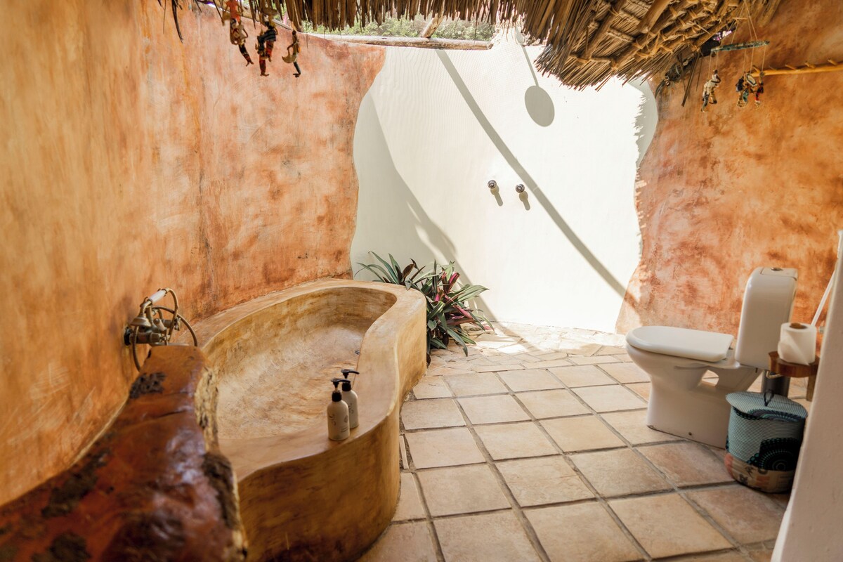 Ein Badezimmer mit Badewanne, Toilette und Duschbereich.