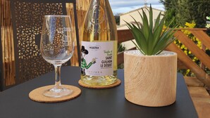 A bottle of wine and a glass on a table with a decorative backdrop. - A sunny interlude (Galargues)
