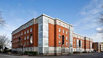 A multi-story building with a mix of brick and glass facades, large windows, and a flat roof.