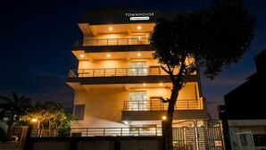 Un edificio de varios pisos con un letrero que dice "TOWNHOUSE" y balcones.