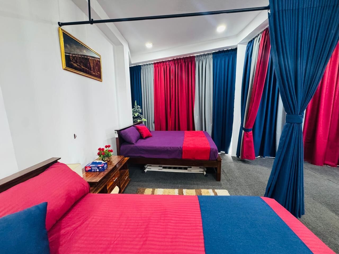 Un dormitorio con dos camas, cabeceros de madera, mesitas de noche con lámparas y una ventana con cortinas.