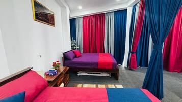 Un dormitorio con dos camas, cabeceros de madera, mesitas de noche con lámparas y una ventana con cortinas.