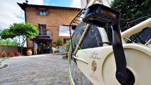Una bicicleta antigua estacionada frente a un edificio con fachada de ladrillo y un balcón.