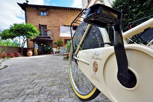 Una bicicletta d'epoca parcheggiata di fronte a un edificio con facciata in mattoni e un balcone.