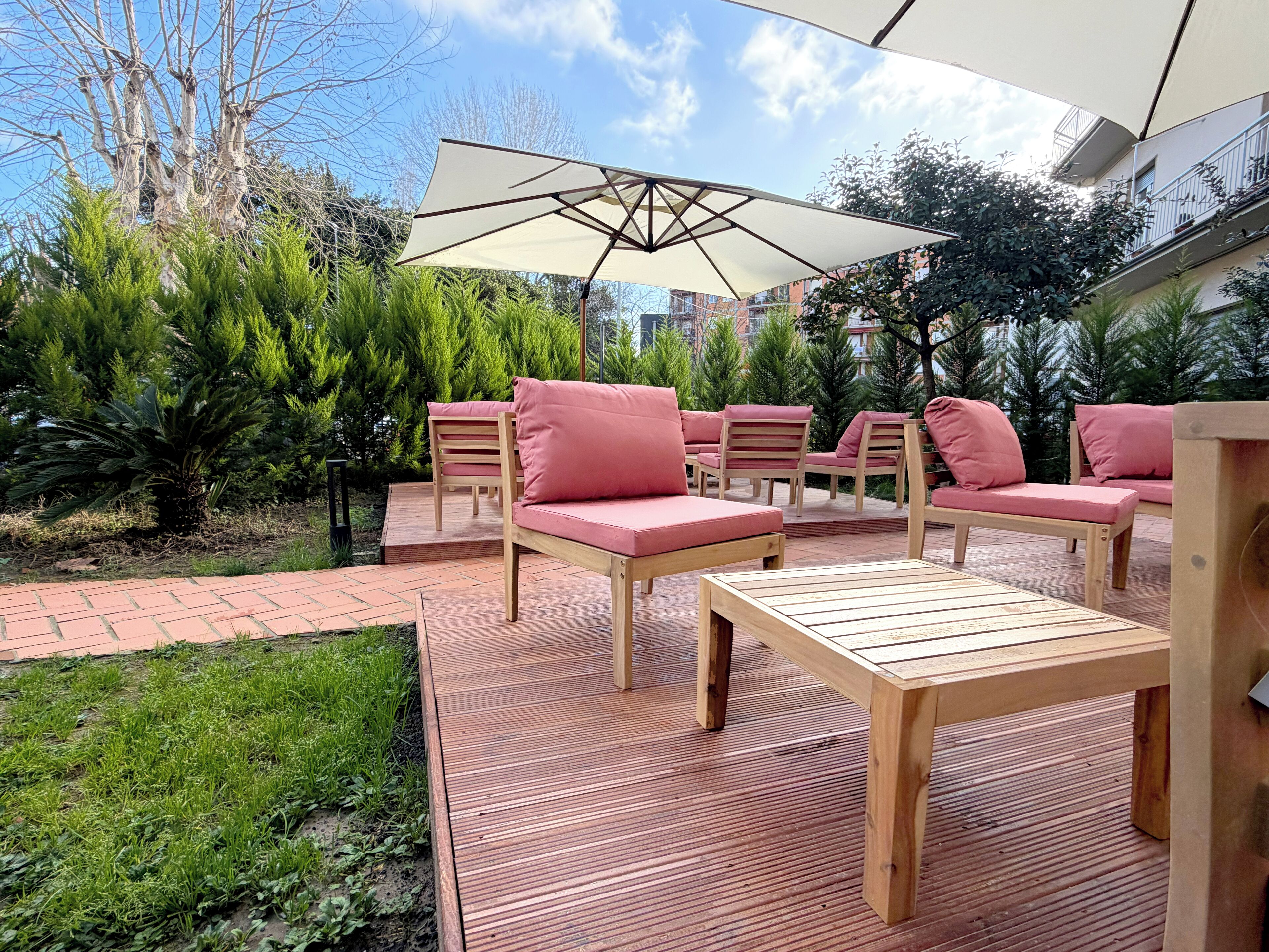 An outdoor patio area with wooden furniture and a large umbrella.