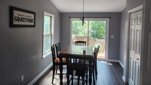 A dining area with a table and chairs, a ceiling fan, and a sign on the wall. - 3-bedroom house in fantastic Atlanta with cool AC and comfort close to downtown (Atlanta)