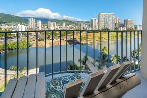 A balcony with a view of a cityscape, a body of water, and a mountainous background. - Free Parking 1BR 1BA Beach Gear Included (Honolulu)