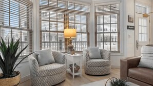 A living room with two patterned armchairs, a coffee table, and a lamp. - The Lakeside Duo | Side-By-Side Beachfront Condos (Sheboygan)