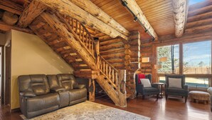 A log cabin interior with a wooden staircase, leather sofa, and two armchairs. - Rustic-Luxury Mountain Retreat Close to Montrose, Ouray, and Telluride (Montrose)
