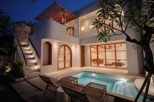 A modern house with a swimming pool, wooden deck, and outdoor seating.