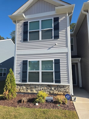 A two-story residential building with a stone foundation, a 'Private Residence' sign, and a 'Secured by ADT' sign.