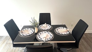 Une table à manger avec quatre assiettes, chacune ornée d’un motif à carreaux et accompagnée d’une serviette pliée.