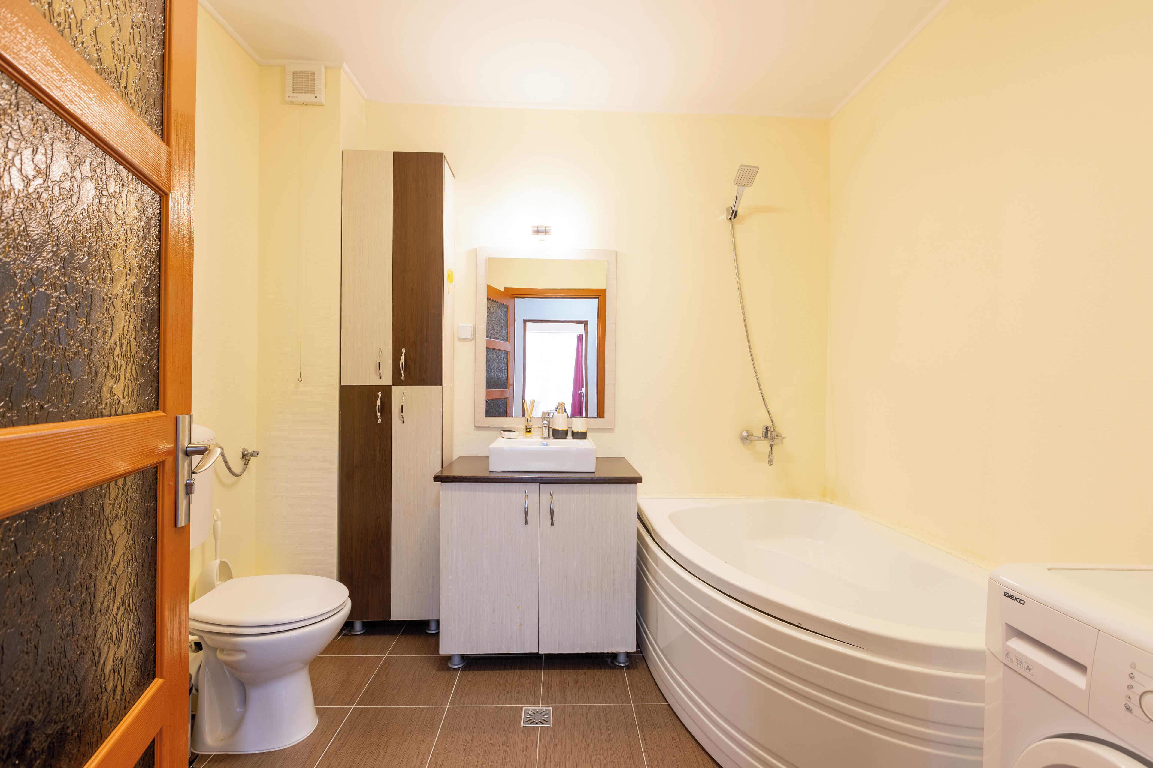 Ein Badezimmer mit Toilette, Waschbecken, Schrank, Dusche und Badewanne.