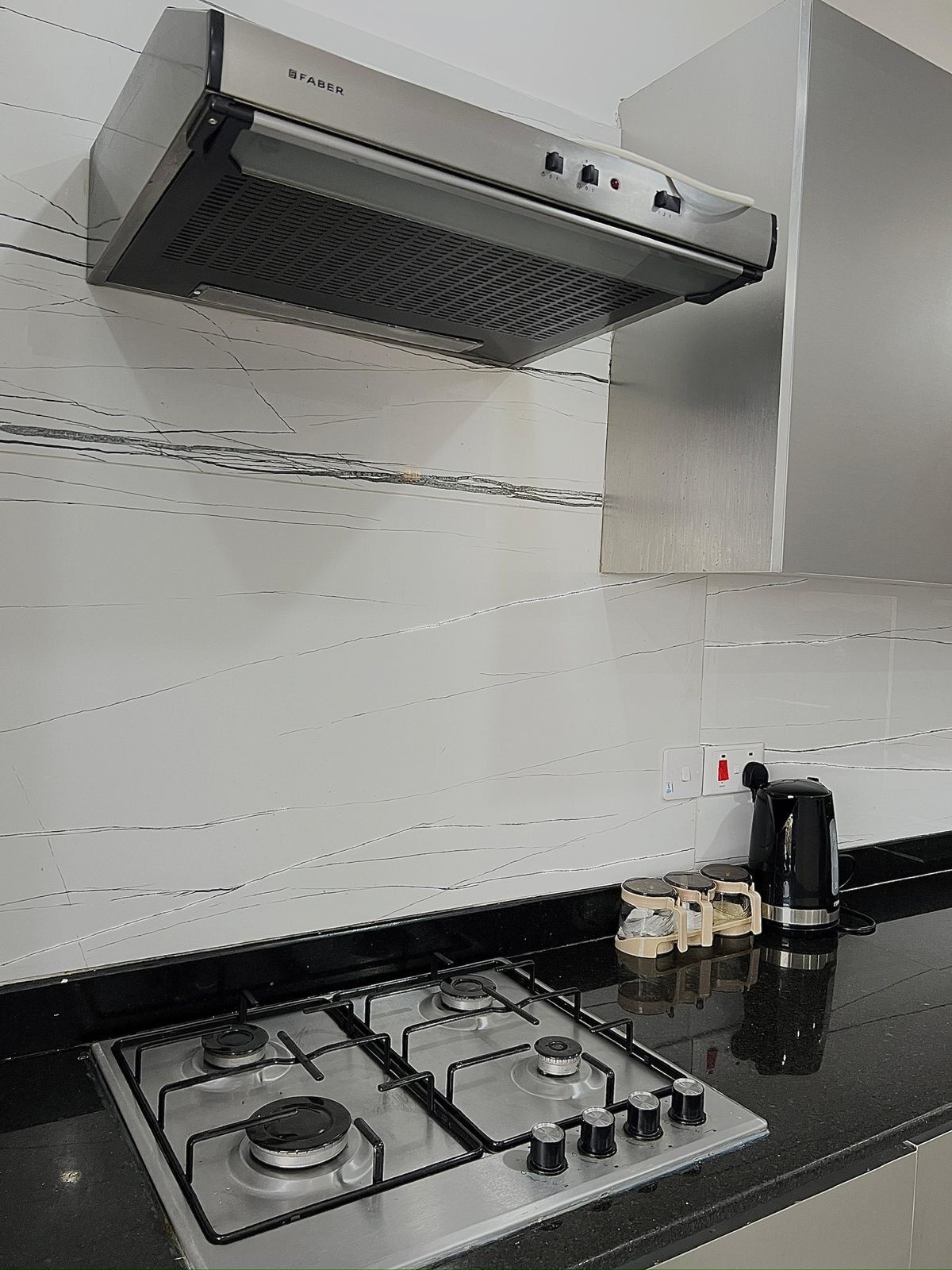 Een koelkast met diepvriezer, een microgolfoven, een oven, een kookplaat