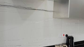 Een koelkast met diepvriezer, een microgolfoven, een oven, een kookplaat