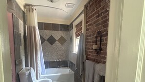 Ein Badezimmer mit Badewanne, Waschbecken und Duschbereich.
